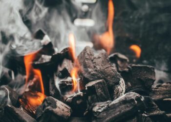 Carvão para churrasco aceso soltando fumaça e chamas