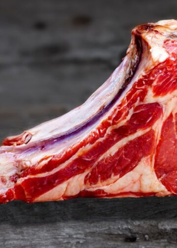 Tomahawk cru com osso longo, corte de carne imponente para churrasco.
