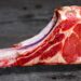 Tomahawk cru com osso longo, corte de carne imponente para churrasco.